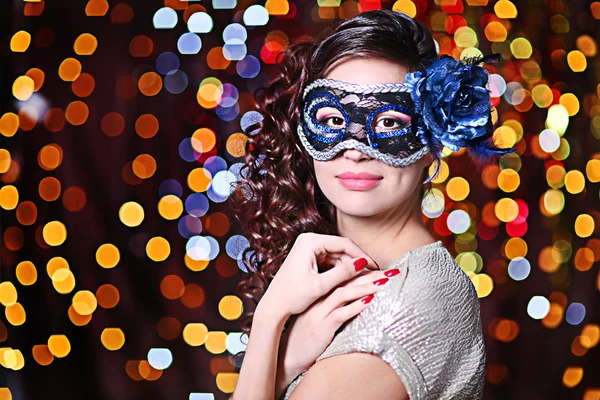 Beautiful girl with masquerade mask on bright background — Stock Photo, Image