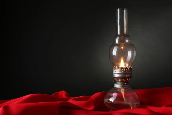 Kerosene lamp on red cloth — Stock Photo, Image