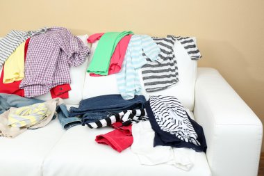 Beyaz koltuk üzerinde dağınık giyim