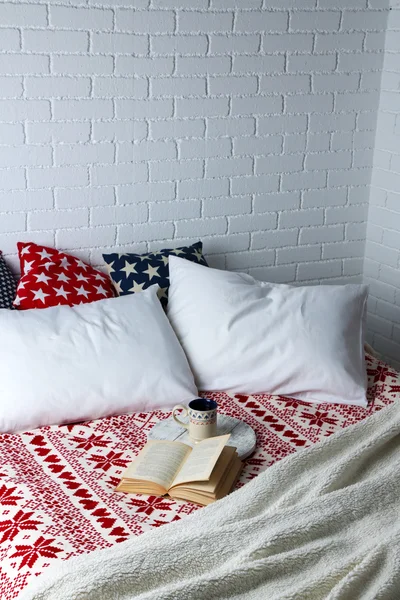 Book and cup on bed