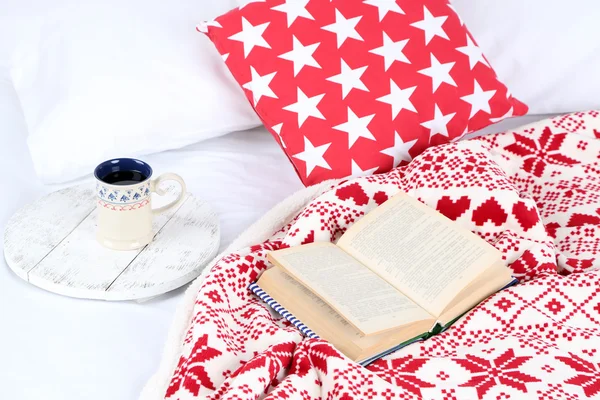 Книга і чашка на ліжку — стокове фото
