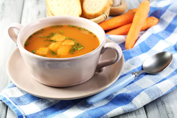 Sopa de zanahoria, crema y cuchara, sobre fondo de madera de color — Foto de Stock