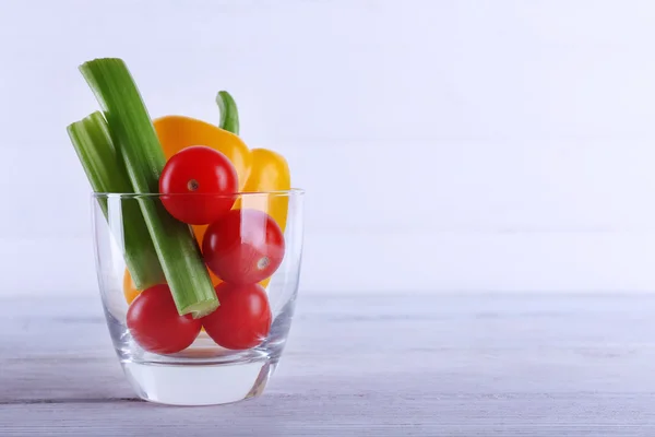 Grönsaker i glas på träplankor färgbakgrund — Stockfoto
