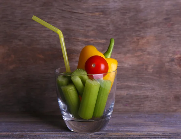 Bâtonnets de céleri au poivre doux et tomate cerise en verre avec tube sur fond bois rustique — Photo