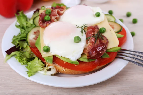 Sandwich dengan telur rebus, daging dan sayuran di piring dengan latar belakang kayu — Stok Foto