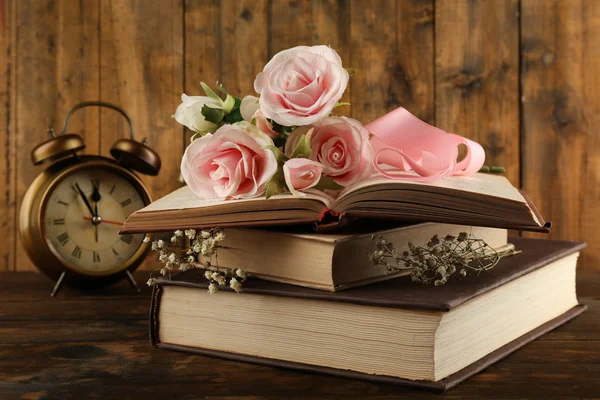 Böcker med blommor och klocka — Stockfoto