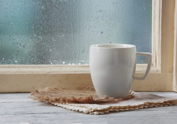 Cup of drink on windowsill — Stock Photo, Image