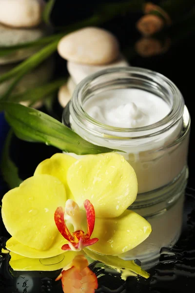 Крем для лица с цветком орхидеи — стоковое фото