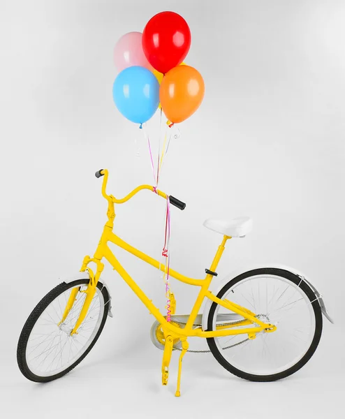 Bicicleta amarela com balões — Fotografia de Stock