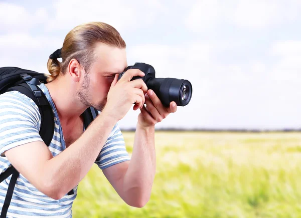 Молодой фотограф фотографирует на открытом воздухе — стоковое фото