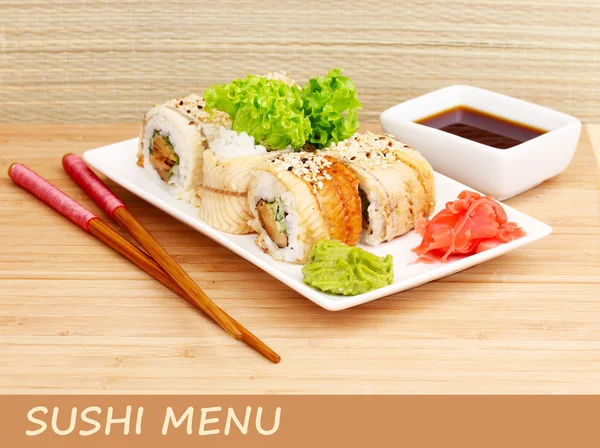 Delicious rolls served on plate on bamboo mat with space for your text — Stock Photo, Image