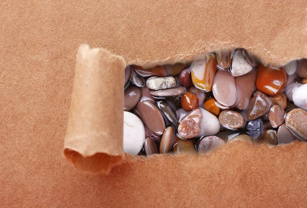 Zee stenen door gescheurd bruin papier — Stockfoto
