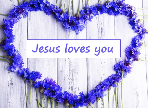 Piękny Chabry i tekst Jezus kocha cię na tle drewniane — Zdjęcie stockowe