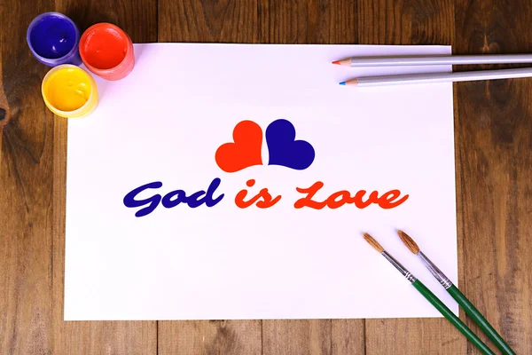 Gott ist Liebestext auf Papier auf Holztischhintergrund — Stockfoto