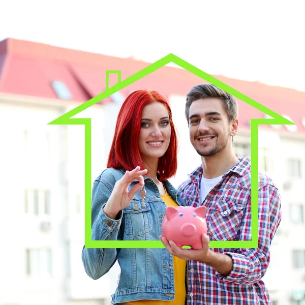 Loving couple with keys and piggy bank in drawing house — Stock Photo, Image