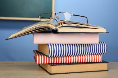 Gözlüklü kitap yığını