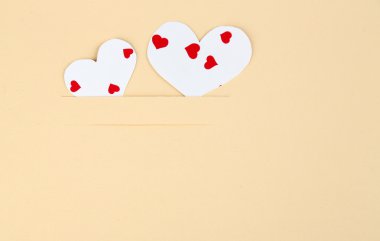 Bej renkli arka plan üzerinde Hearts kağıt, yakın çekim