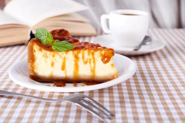 Torta di formaggio e tazza di caffè sulla tovaglia su sfondo tenda — Foto Stock