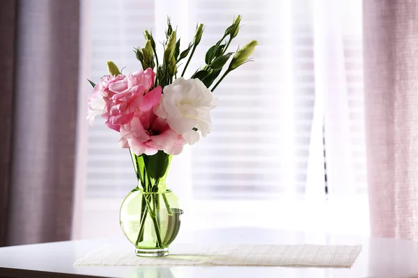 Mooie bloemen in vaas met licht uit raam — Stockfoto