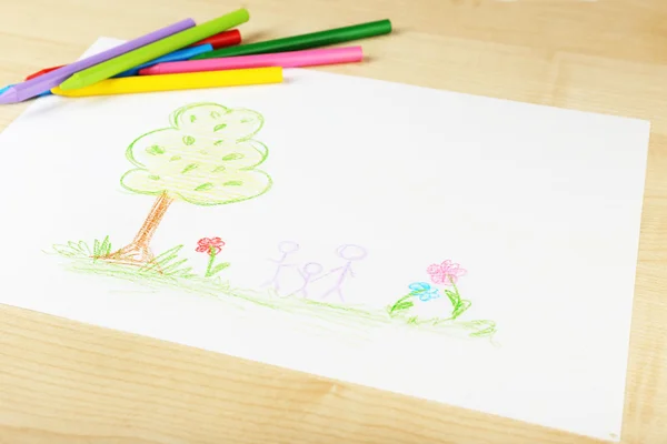 Dessin réalisé par un enfant avec des crayons colorés sur fond de table en bois — Photo