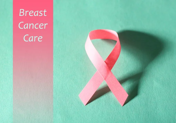 Pink breast cancer ribbon on turquoise background — Stock Photo, Image