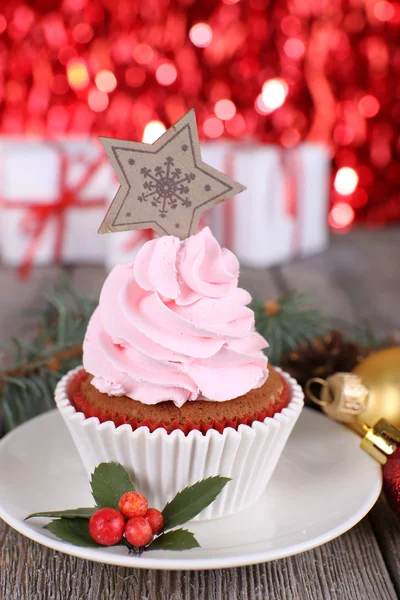 Tasse-Kuchen mit Sahne auf Untertasse und Weihnachtsdekoration auf Holztisch und leuchten hell Hintergrund — Stockfoto