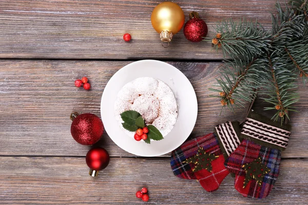 Bolo delicioso no pires com azevinho e baga na decoração de Natal e fundo de madeira — Fotografia de Stock