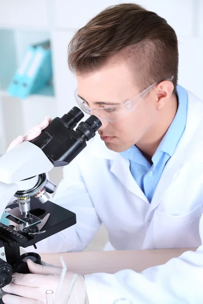 男性科学家在实验室使用显微镜 — 图库照片