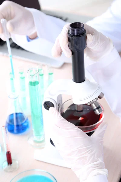 Male and female scientists hands using microscope in laboratory — Stock Photo, Image