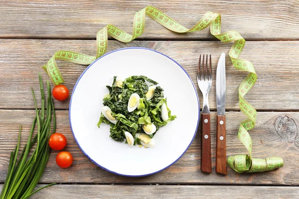 Salat mit Wachtelei und Basilikum im Teller mit Maßband auf rustikalem Holztischhintergrund — Stockfoto