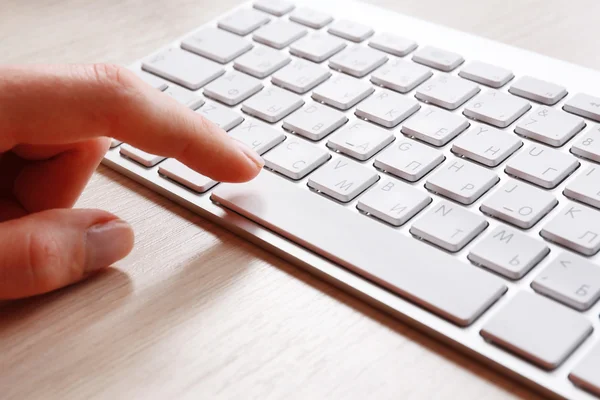 Mão feminina com teclado no fundo do desktop de madeira — Fotografia de Stock