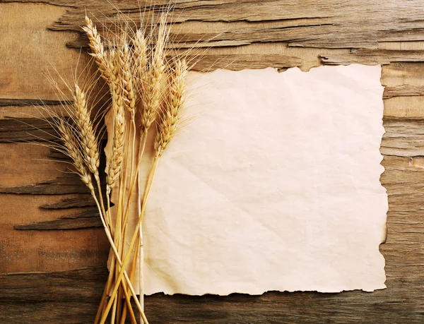 木製の背景紙と小麦の穂 — ストック写真