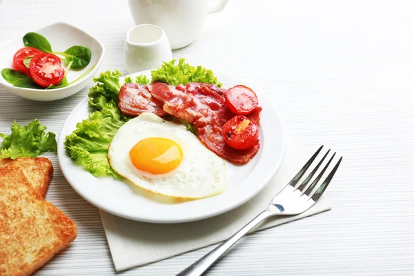 Bacon e ovos na cor de fundo de mesa de madeira — Fotografia de Stock