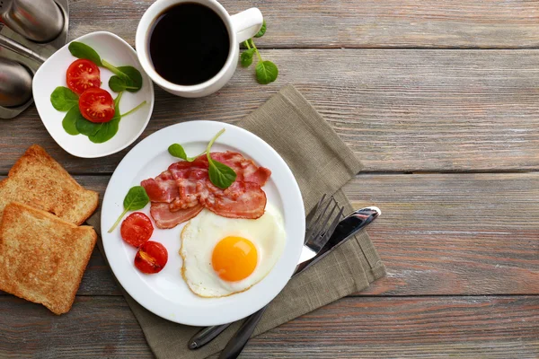 Bacon et oeufs sur des planches rustiques en bois fond — Photo