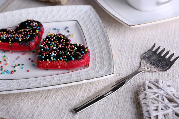 Cookies in form of heart on plate and napkin background — Stock Photo, Image