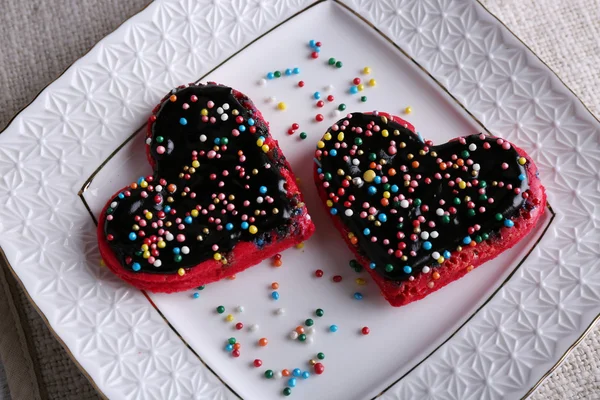 Cookies in form of heart on plate and napkin background — Stock Photo, Image