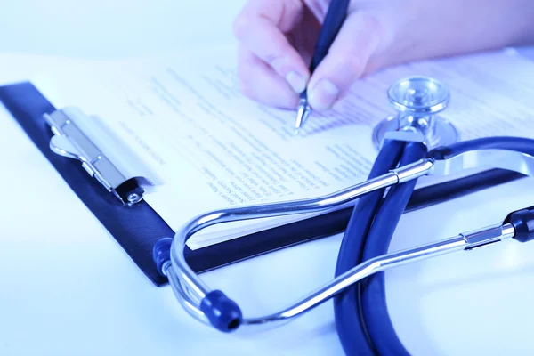 Mujer llenando historia médica en fondo claro — Foto de Stock