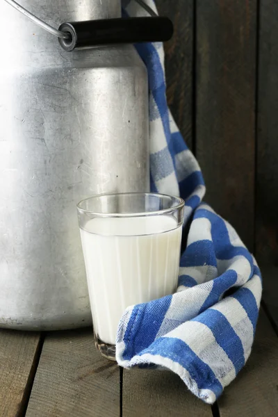 Retro-Dose für Milch mit buntem Handtuch auf farbigem Holzhintergrund — Stockfoto