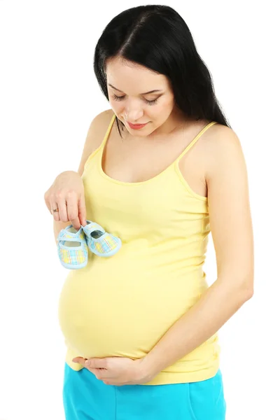 Krásná mladá těhotná žena s baby obuv izolovaných na bílém — Stock fotografie