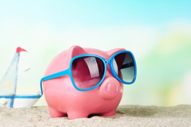 Sahilde güneş gözlüğü ile Piggy banka