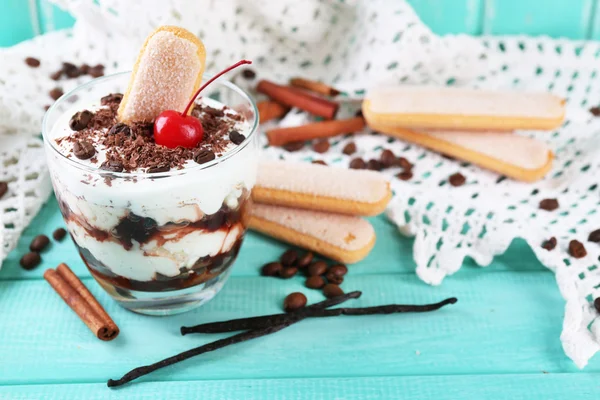 Tasty tiramisu dessert in glass, on color wooden background — Stock Photo, Image