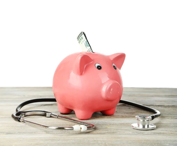 Pink piggy bank with stethoscope on white background — Stock Photo, Image