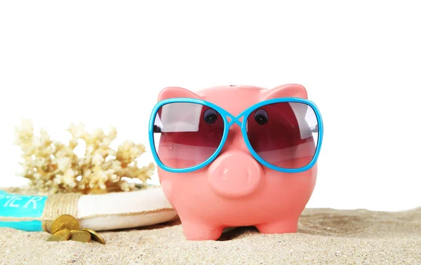 Banco Piggy com óculos de sol na areia, no fundo branco — Fotografia de Stock