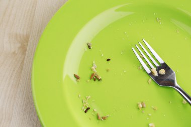 Plate with crumbs on wooden background  clipart
