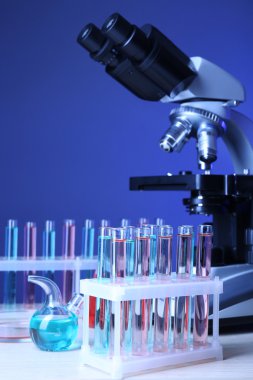 Mikroskop ve masaya renk arka plan üzerinde test tüpleri
