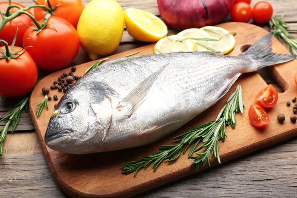 Frischer roher Fisch und Lebensmittelzutaten auf dem Tisch — Stockfoto