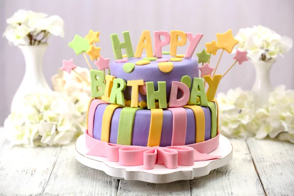 Lezzetli doğum günü pastası ışık arka plan üzerinde masada — Stok fotoğraf