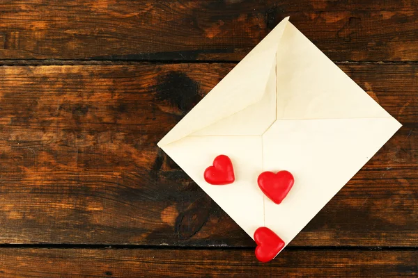 Empty envelope with hearts on rustic wooden table background — Stock Photo, Image