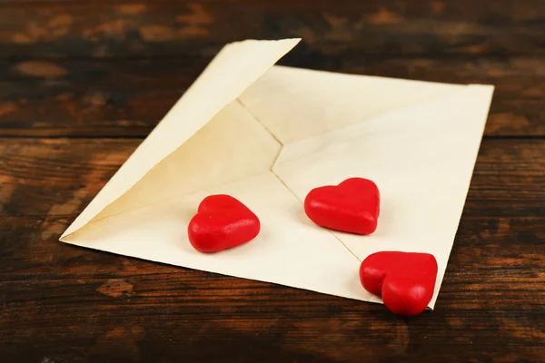 Empty envelope with hearts on rustic wooden table background — Stock Photo, Image