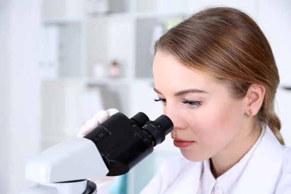 Jonge vrouwelijke wetenschapper met Microscoop in laboratorium — Stockfoto